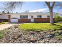 Charming single-story home with a brick facade, well-manicured lawn, and decorative rock garden in front at 1275 Berea Dr, Boulder, CO 80305