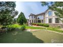 Spacious backyard with putting green, large patio, and mature trees at 1521 Orion Pl, Longmont, CO 80504