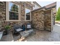 Cozy outdoor patio features stone accents, ample seating, and relaxing atmosphere at 1521 Orion Pl, Longmont, CO 80504