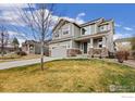 Attractive two-story home with well-manicured lawn, grey siding, and a two-car attached garage at 16848 Weber Way, Mead, CO 80542