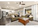 Open concept living area featuring two sofas, large windows and seamless kitchen access at 16848 Weber Way, Mead, CO 80542
