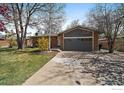 Charming home featuring a two-car garage, brick accents, and beautiful landscaping at 1746 Shavano St, Longmont, CO 80504