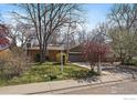 Inviting home with a lovely front yard, mature trees, and a paved walkway at 1746 Shavano St, Longmont, CO 80504