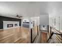 Open-concept living area featuring a brick fireplace, hardwood floors, and a breakfast bar overlooking the kitchen at 1746 Shavano St, Longmont, CO 80504