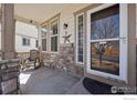 Inviting front porch with stone accents, a rocking chair, and stylish details create a cozy entrance to the home at 1865 Trevor Cir, Longmont, CO 80501
