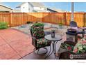 A cozy backyard setup with comfortable seating, a table, and raised garden beds against a wooden fence at 226 Ole Bessie Dr, Berthoud, CO 80513