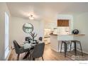Dining area with a modern glass table and view to the kitchen featuring bar seating at 2800 Kalmia Ave # C212, Boulder, CO 80301