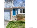 Close up of the front entrance featuring a bright blue door and lush landscaping at 3032 W Yarrow Cir, Superior, CO 80027