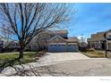 Charming two-story home with a three-car garage and spacious driveway on a sunny day at 355 Sprucewood Ct, Lafayette, CO 80026