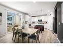 Open-concept dining area features hardwood floors, a modern table with six chairs, and lots of natural light at 364 Shawnee Ln, Superior, CO 80027