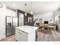 Open-concept kitchen with white cabinets, stainless steel appliances, and a large island at 364 Shawnee Ln, Superior, CO 80027