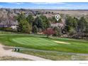 Scenic aerial view of a home on a golf course with mature trees and a beautiful landscape at 4207 Birdie Ct, Longmont, CO 80503
