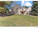 Charming two-story home with a well-manicured lawn and mature trees, showcasing its classic architecture at 4207 Birdie Ct, Longmont, CO 80503