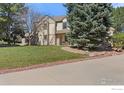 Charming two-story home with a well-manicured lawn and mature trees, showcasing its classic architecture at 4207 Birdie Ct, Longmont, CO 80503