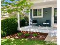 Inviting covered porch with seating, complemented by landscaped garden and greenery at 506 Entrada Dr, Golden, CO 80401
