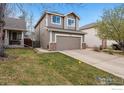 Two-story home with a two-car garage and a well-manicured lawn at 6774 St Vrain Ranch Blvd, Firestone, CO 80504