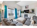 Bright living room with vaulted ceilings, a fireplace, and large windows at 6774 St Vrain Ranch Blvd, Firestone, CO 80504
