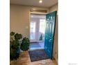 Inviting foyer with a vibrant blue door, hardwood floors, and stylish decor at 7170 Zuni St, Denver, CO 80221