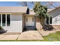 Inviting front entrance with white double doors, complemented by neat landscaping and a brick accent wall at 1030 55Th St, Boulder, CO 80303