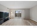 Bright living room featuring modern floors and a sliding glass door to the outside at 12113 Melody Dr # 104, Denver, CO 80234