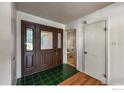 Welcoming foyer with striking green tile flooring and a glimpse into an adjacent half bathroom for guests at 12891 Columbine Dr, Longmont, CO 80504
