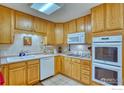 Functional kitchen featuring wood cabinets, tiled backsplash, and essential appliances at 1540 W 106Th Ave, Northglenn, CO 80234