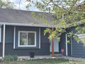 Single-story home features gray siding, a brick foundation, a bright white front door, and manicured front yard at 1701 Sumner St, Longmont, CO 80501