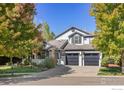 Beautifully landscaped two-story home with mature trees, a well-manicured lawn, and a spacious three-car garage at 2001 Coralbells Ct, Longmont, CO 80503
