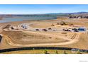 Aerial view of construction site near lake and mountains, showing street layout and equipment at 2682 Southwind Rd, Berthoud, CO 80513