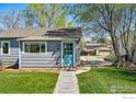 Close up of the home's exterior featuring a quaint blue front door and well-kept lawn at 285 Holbrook St, Erie, CO 80516