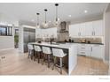 Modern kitchen with white cabinetry, quartz countertops, stainless steel appliances, and stylish pendant lighting at 2860 Table Mesa Dr, Boulder, CO 80305