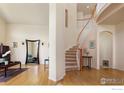 Inviting foyer featuring a curved staircase, hardwood floors, and a large decorative mirror at 4027 Guadeloupe St, Boulder, CO 80301