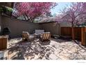 Inviting patio seating area shaded by a blooming tree, featuring a grill and outdoor storage at 4654 Greenbriar Ct, Boulder, CO 80305