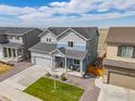 Two-story home with blue accents, green lawn and neighboring homes with a view of open land at 5453 Bauer Dr, Frederick, CO 80504