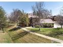 Lovely view of a brown townhome with lush lawn, trees, and a sidewalk at 6251 Willow Ln, Boulder, CO 80301