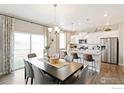 Open-concept kitchen featuring stainless steel appliances, quartz countertops, and a sun-filled dining area at 6525 14Th St, Frederick, CO 80530