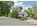 Exterior view of a home with a circular driveway and mature trees at 6903 Valmont Rd, Boulder, CO 80301