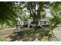 Charming home exterior with patio, outdoor seating, and mature trees at 6903 Valmont Rd, Boulder, CO 80301