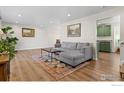 Comfortable living room with wood floors, gray sofa, and modern decor at 7203 S Cody Way, Littleton, CO 80128