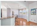 Cozy dining area featuring hardwood floors, a bay window, and a breakfast bar at 10071 E 142Nd Ave, Brighton, CO 80602
