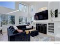 Bright living room with soaring ceilings, large windows, fireplace, and comfortable seating area at 10081 Blackbird Cir, Highlands Ranch, CO 80130