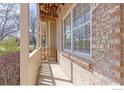 Charming front porch with a brick facade and covered entrance at 104 Pheasant Run, Louisville, CO 80027