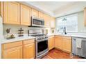 Well-lit kitchen with wood cabinets, stainless steel appliances, and quartz countertops at 1065 Laramie Blvd # F, Boulder, CO 80304