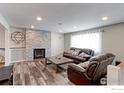 Cozy living room with a decorative fireplace, hardwood floors, comfortable furniture, and recessed lights at 10679 Union Way, Broomfield, CO 80021