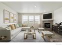 Elegant living room featuring a cozy fireplace, comfortable seating, and ample natural light for relaxation at 1884 Sawtooth Mountain Dr, Berthoud, CO 80513