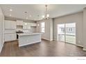 Bright, open-concept kitchen with stainless steel appliances, an island, and hardwood floors. Sliding doors to backyard at 1898 Westport Ave, Berthoud, CO 80513
