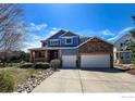 Charming two-story home with stone accents, a front porch, and a spacious driveway at 2000 Prestwick Ct, Longmont, CO 80504