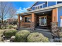 Inviting front porch with stone pillars and well manicured landscaping, offering curb appeal at 2000 Prestwick Ct, Longmont, CO 80504