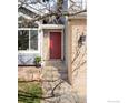 Close up of a red front door with brick accents and stone steps leading up to the entrance at 221 S Lark Ave, Louisville, CO 80027