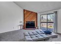Bright living room features a cozy fireplace, plush carpeting, and sliding doors to a private balcony at 2879 Shadow Creek Dr # 306, Boulder, CO 80303